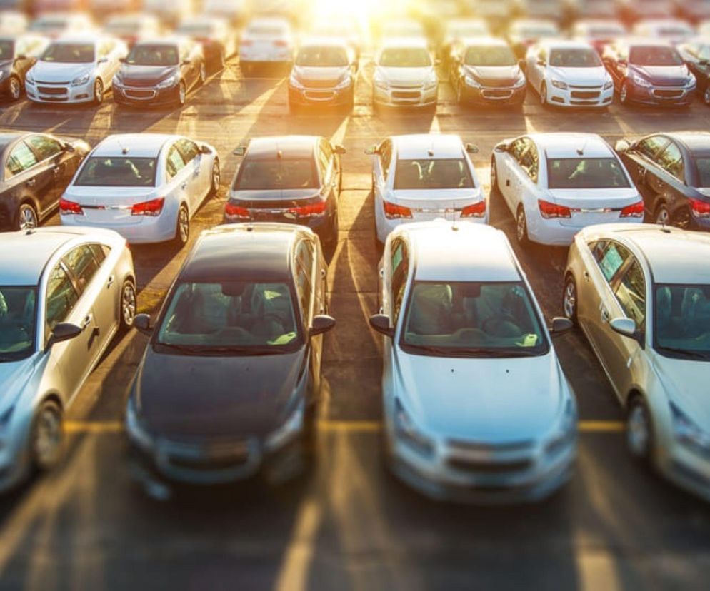Rzędy samochodów na pełnym parkingu w świetle słońca. O inwestycji w Przytyku przeczytasz na Eska Radom.