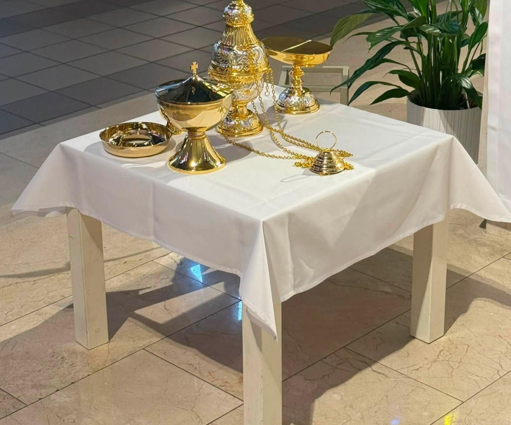 Złote naczynia liturgiczne na białym stoliku w kościele. O nowym trybularzu i łódce przeczytasz na Radioplus.