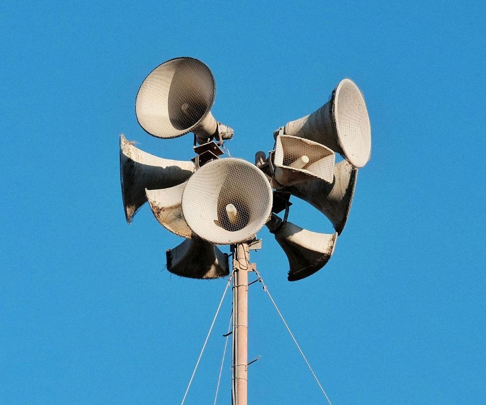 Sześć głośników syreny alarmowej na wysokim maszcie na tle nieba. O ćwiczeniach w Gorzowie informuje Radioplus.