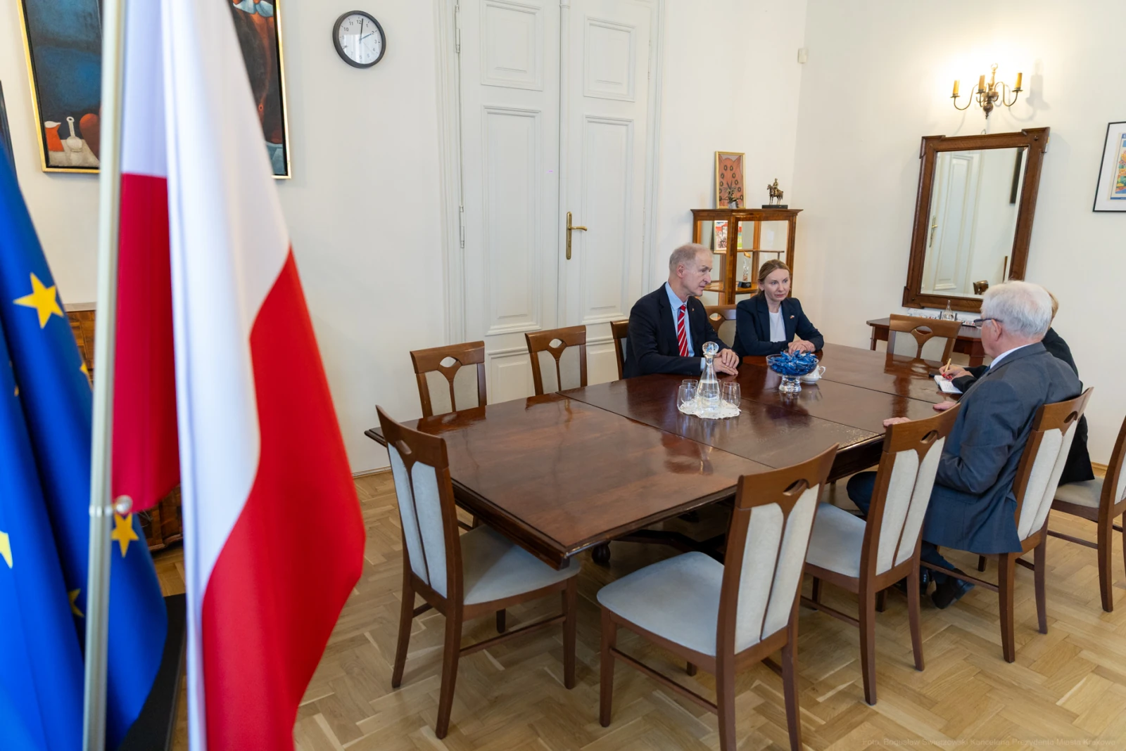 Spotkanie w sali konferencyjnej z flagami Polski i UE w tle. Autor: Bogusław Świerzowski
